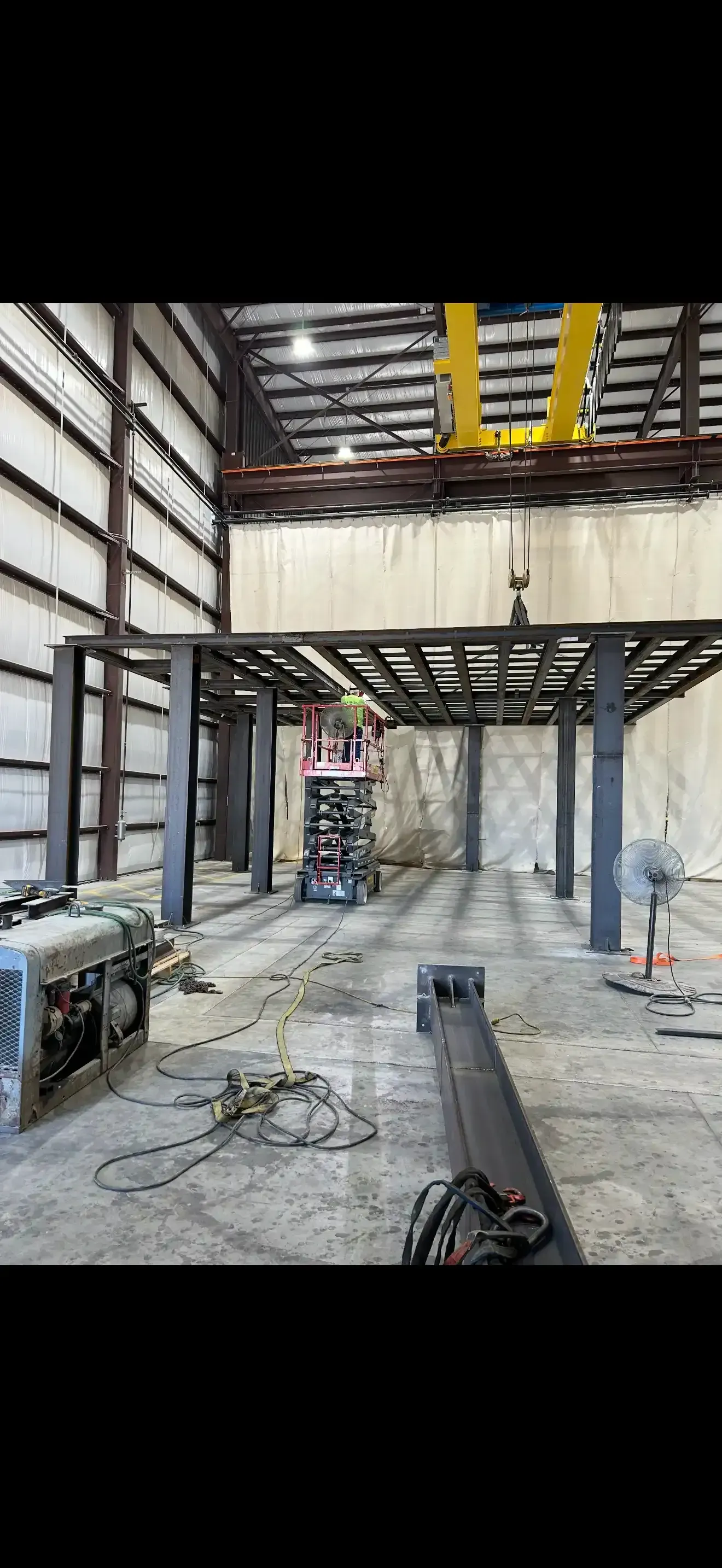 Construction site with steel beams, lift platform, and machinery in a large building in Las Vegas.