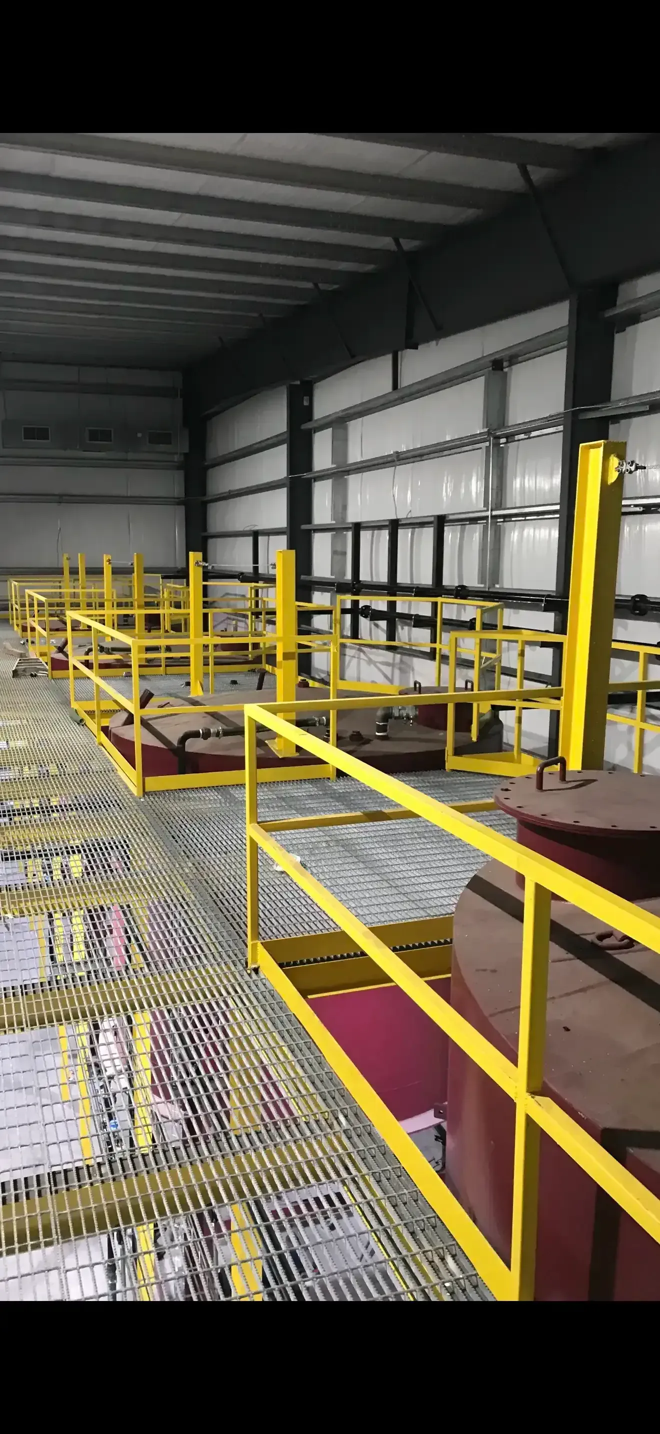 An industrial interior with yellow safety railings and a metal grated floor in Las Vegas.